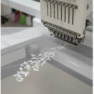 Stickmaschine zum Vernähen von zartem Spitzenstoff für Brautschleier.