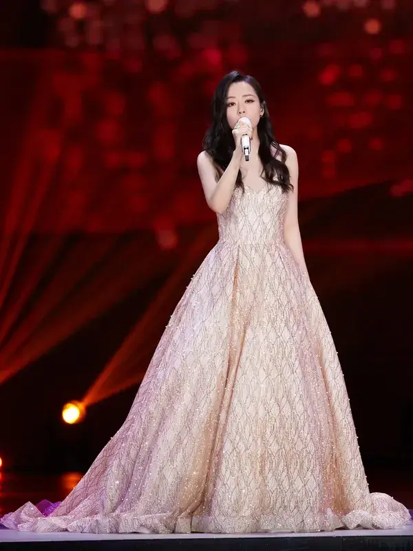 Singer Jane Zhang performing on a national stage in a golden ball gown  for one of our designer partners.