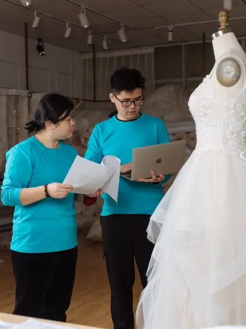 Smiling factory staff member working in a bridal gown workshop