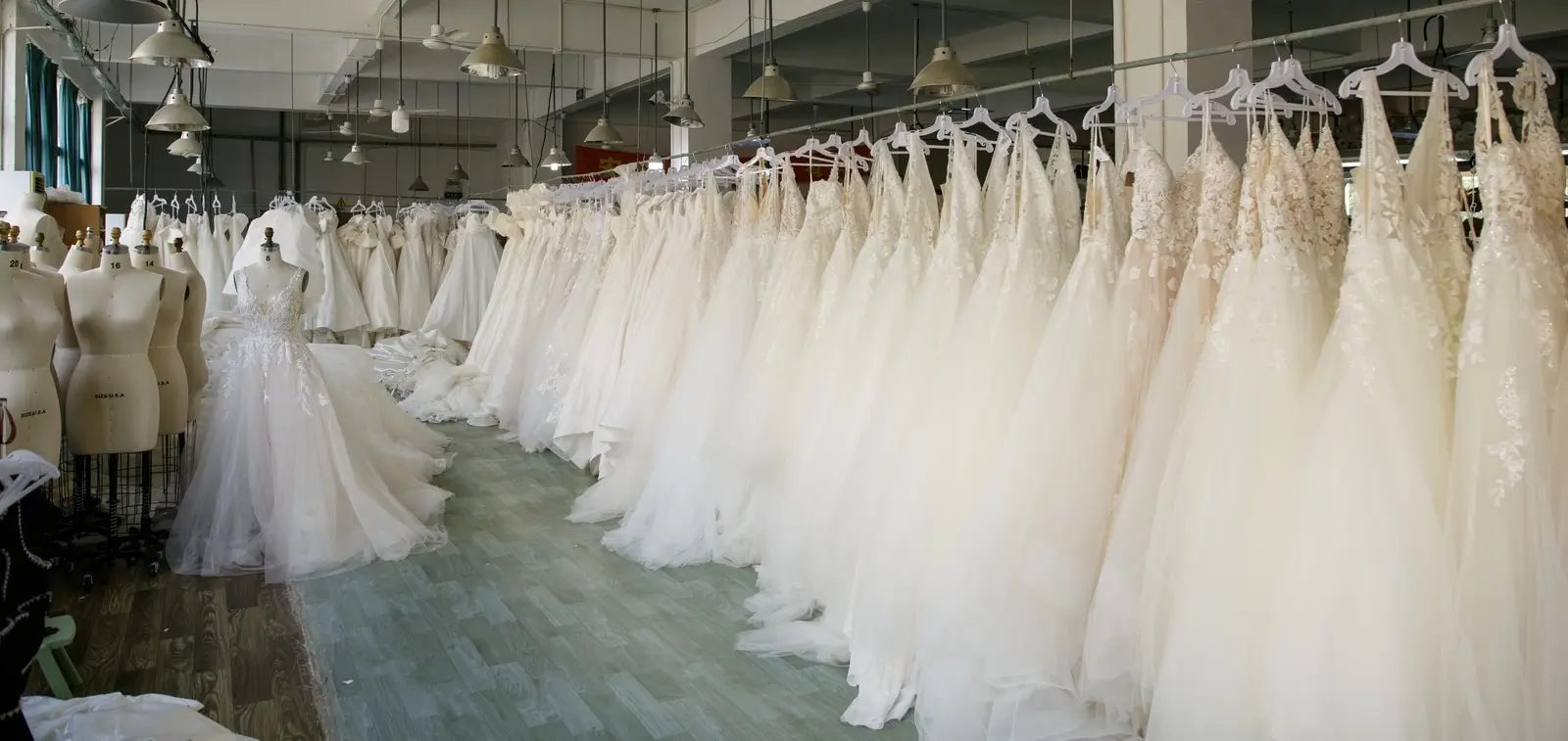 Massive inventory of finished wedding dresses at AiDo factory, demonstrating high-volume production capacity for global bridal brands.